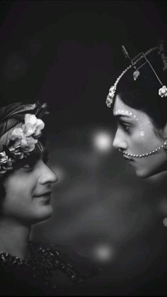 black and white photograph of two women wearing headdresses with flowers in their hair