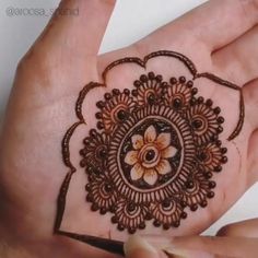 someone is holding their hand with a henna on it's palm and the flower in the middle