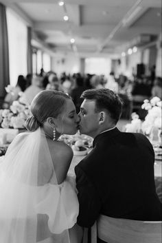 a man and woman kissing each other at a dinner table