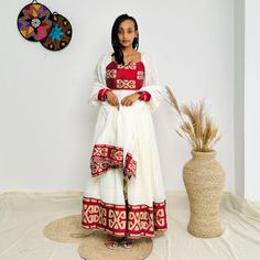 This stunning red Habesha dress features a stylish crop top and matching skirt, designed to bring bold elegance to any occasion. The intricate patterns on the fabric add a touch of traditional craftsmanship while the modern crop and skirt style offer a chic and contemporary look. Perfect for standing out at cultural events, parties, or casual outings, this unique Habesha dress effortlessly combines tradition with a modern twist. Key Features: Cultural Heritage: Adorned with exquisite handwoven details that honor Ethiopia's rich traditions. Flattering Design: The flowing silhouette ensures you look stunning at weddings, festivals, or any event where you want to shine. Ethical Craftsmanship: Handmade by skilled Ethiopian artisans, embracing tradition while making a bold fashion statement. Ca Crop And Skirt, Habesha Dress, Ethiopian Dress, Habesha Kemis, Stylish Crop Top, Cultural Events, Skirt Style, Cultural Heritage, Intricate Patterns