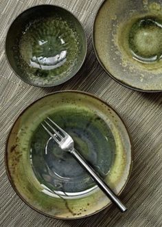 three bowls with forks in them sitting on a table