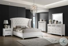 a bedroom with black walls, white furniture and a chandelier hanging from the ceiling