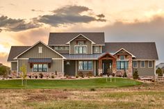 a large house with lots of windows on the front and side of it, surrounded by grass