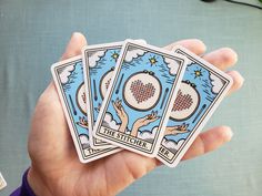 three tarot cards held in the palm of someone's hand, which is holding them