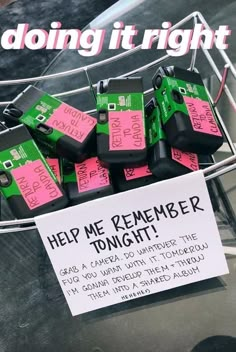 a bunch of pink and green boxes sitting on top of a metal rack next to a sign that says help me remember tonight