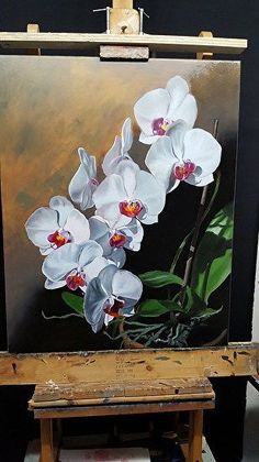 an easel with a painting of white orchids on it