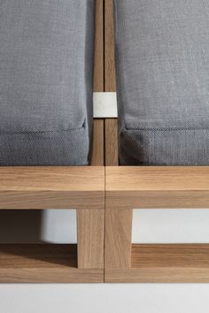 two gray pillows sitting on top of a wooden shelf