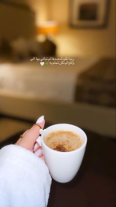 a woman's hand holding a cup of coffee