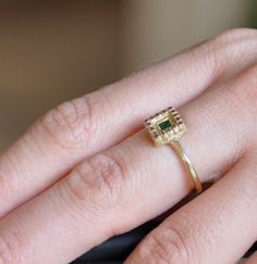 "14k solid gold ring with a central Emerald gemstone and 16 beautiful Rubies surrounding it. The ring is square, representing antique, Indian continent style. This stunning ring sits gently on the finger with a clear, strong presence. The ring is all handmade, hand carved as one single unit, no soldering, engraved in cold wax technique and casted in 14k gold. The gold , Emerald and Ruby combination are characteristic of India and a jewelry style which I love so much. **14k solid gold ** Green ge Heirloom Gold Emerald Ring With Halo Detail, Heirloom Gold Emerald Ring With Halo, Fine Jewelry Ring With Square Cut Rose Diamonds, Gold Multi-stone Rectangular Ring, Gold Square Cut Emerald Ring With Gemstone, 14k Gold Rectangular Rose Cut Diamond Rings, Square Cut Emerald Rings In Gold, Square Cut Emerald Gold Rings, Gold Square Cut Gemstone Diamond Ring