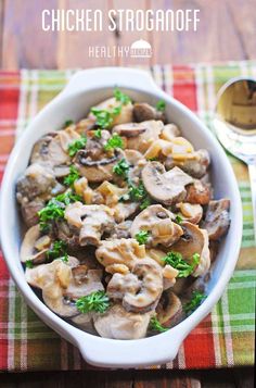 chicken stroganoff with mushrooms and parsley in a white bowl on a colorful tablecloth