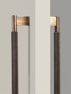 two tall metal poles are standing next to each other on the wall in front of a white and gray background