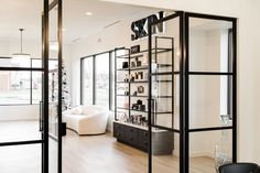 the interior of a modern salon with black and white furniture, large windows, and wooden flooring