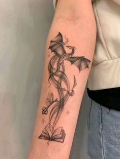 a woman's arm with a tattoo on it and an image of a book