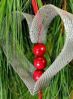 a heart shaped ornament hanging from a pine tree