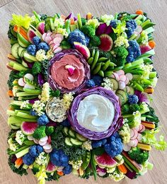 an arrangement of vegetables arranged in the shape of a flower on a wooden table top