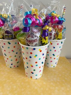 three buckets filled with candy on top of a table