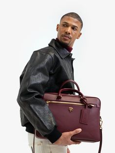 Classic gentlemen briefcase in matte grained leather, gold crest at front, signature green canvas lining with zipper pocket, leather handles, gold industrial hardware, and detachable leather strap and name tag. -100% Leather -Color: Cabernet -Length: 39cm -Height: 27cm -Width: 8cm -Strap: 135cm -Care: Leather specialist only -Made in Turkey Designer Leather Briefcase With Zipper Closure, Luxury Briefcase With Zipper Closure For Business Trips, Luxury Briefcase With Zipper For Business Trips, Designer Textured Leather Briefcase For Business, Designer Textured Leather Briefcase For Work, Designer Briefcase With Zipper Closure For Business Trips, Classic Briefcase With Gold-tone Hardware For Business Trips, Leather Briefcase With Gold-tone Hardware For Business Trips, Designer Briefcase With Gold-tone Hardware For Work