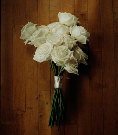 a bouquet of white flowers sitting on top of a wooden floor