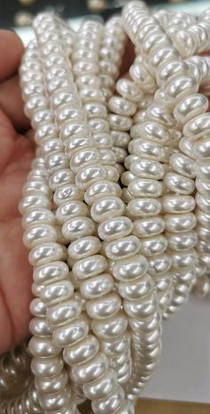 white pearls are being held by someone's hand