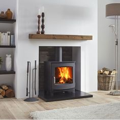 an image of a fire place in the middle of a living room with wood burning