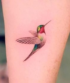 a small hummingbird tattoo on the right side of the leg, it's colorful