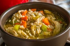 a bowl filled with chicken, carrots and celery next to a napkin