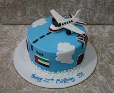 a birthday cake decorated with an airplane and the flag of italy on it's side