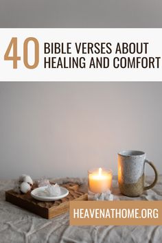 a table topped with a cup and plate next to a candle on top of a bed