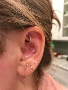 a close up of a person's ear with two piercings on it and one behind the ear