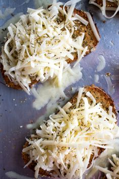 two pieces of bread topped with cheese and parmesan