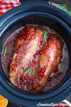 two meats in a slow cooker with cranberry sauce