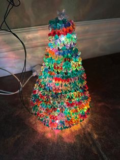 a multicolored christmas tree is lit up on the floor