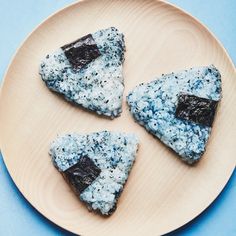 three pieces of blueberry cheesecake on a wooden plate with black and white sprinkles