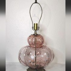 a pink glass lamp sitting on top of a table