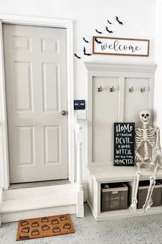 a skeleton sitting on a bench in front of a door with a welcome sign above it