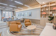 a living room filled with lots of furniture and decor on top of carpeted flooring