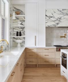 a kitchen with white marble counter tops and wooden flooring, along with open shelving