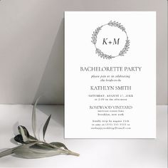 a white wedding card with a wreath on it