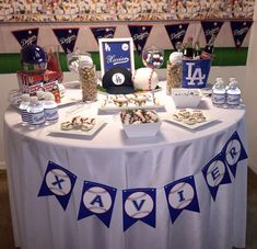 a table topped with lots of food next to bunting and flags on the wall