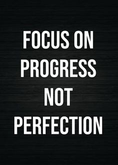 the words focus on progress not perfection written in white on a black wood grained background