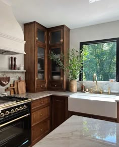 a kitchen with marble counter tops and wooden cabinets, along with a white stove top oven