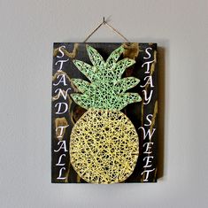 a string art pineapple hanging on a wall