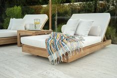 an outdoor daybed with pillows and blankets on it