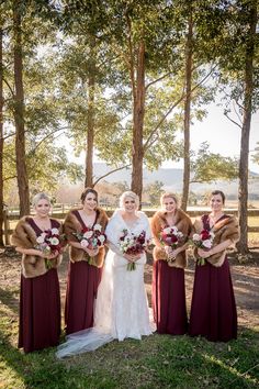 the bride and her bridesmaids pose for a photo in front of some trees