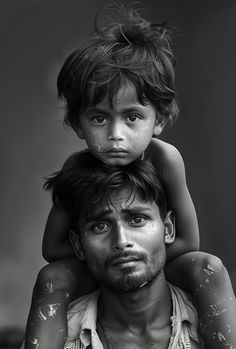 Prompt - Black-and-white photograph of a Bangladeshi child sitting on the shoulders with a puppy of their father, both wearing tattered , looking up at the camera with hope in their eyes, set against a plain background, evoking emotions of love and compassion. --ar 60:89 Rangoli Images, Love And Compassion, Plain Background, Plains Background, Asia Destinations, A Puppy, Black And White Photographs, Human Rights, Looking Up