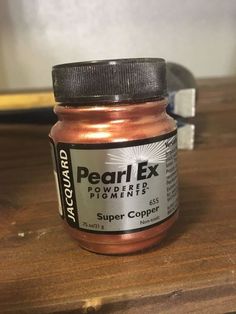 a jar of pearl ex powder sitting on top of a wooden table