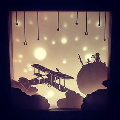 the silhouette of an airplane is shown in front of a window with stars hanging from it