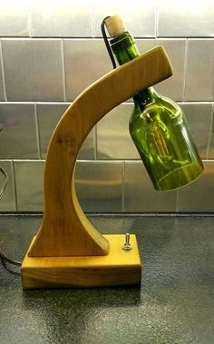 a green glass bottle sitting on top of a wooden stand