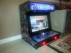 an old fashioned video game sitting on top of a floor next to a rug and wall