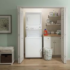 a washer and dryer sitting in the corner of a room with green walls